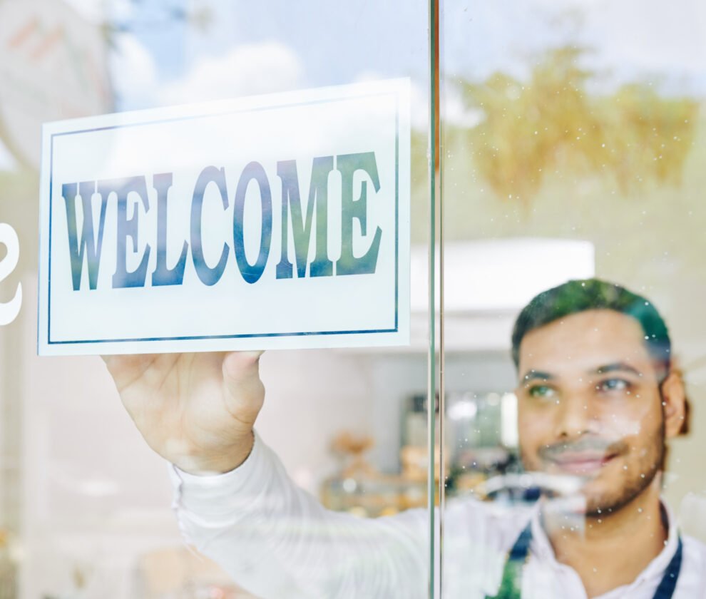 Shop owner sticking welcome sign
