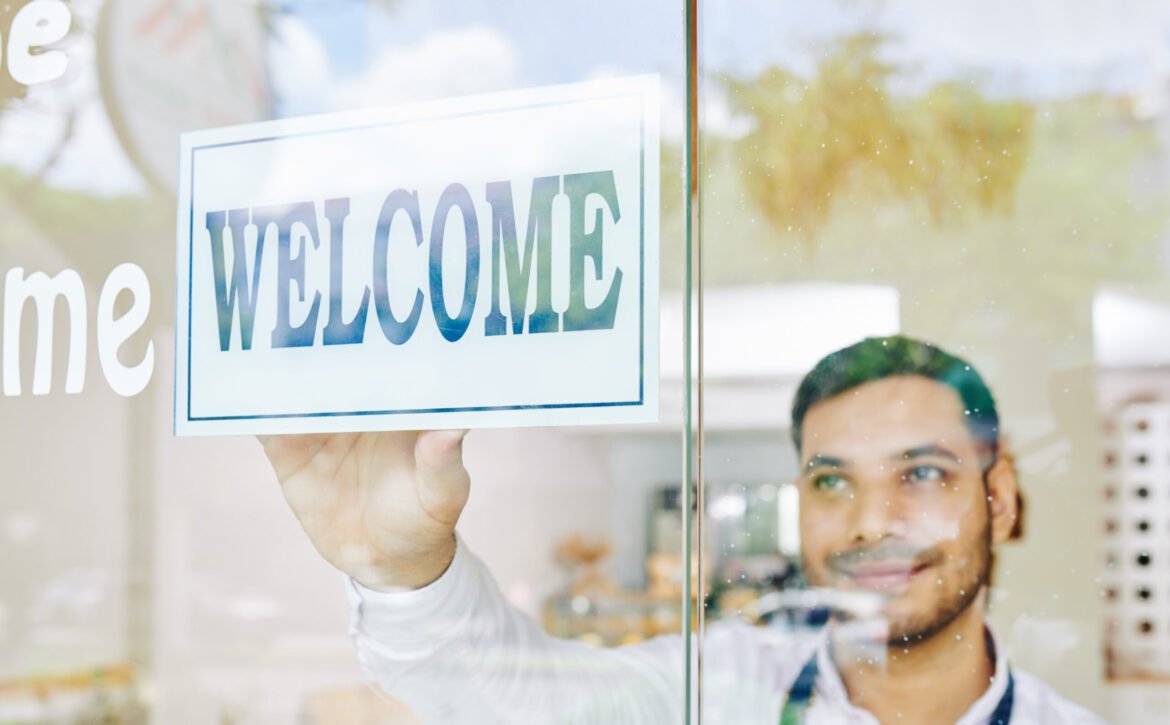 Shop owner sticking welcome sign